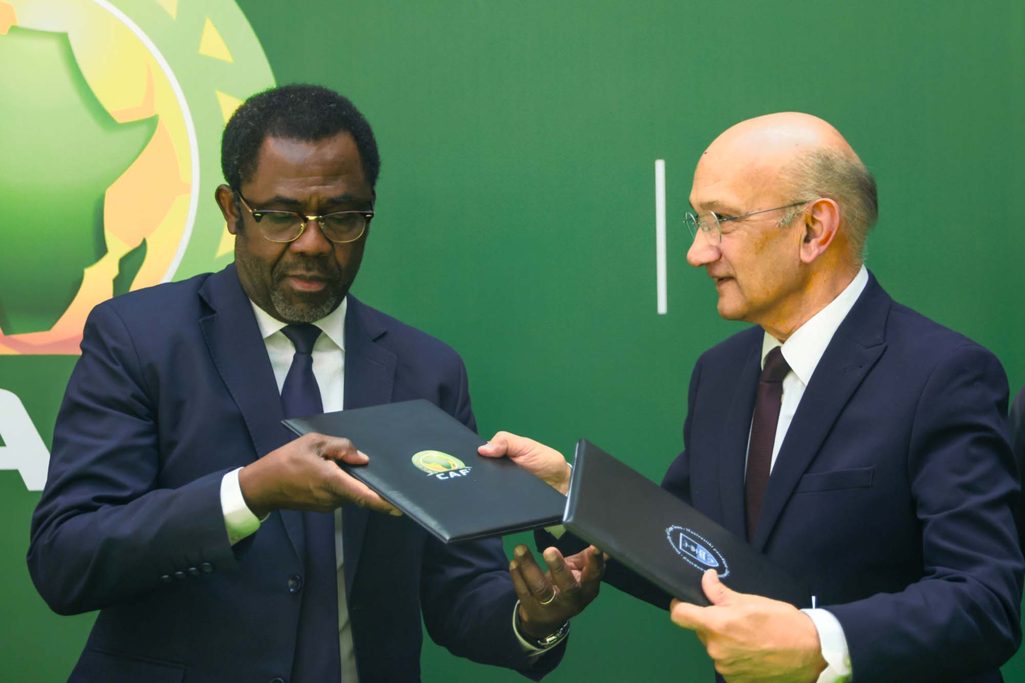 CAF Secretary General, Mr Veron Mosengo-Omba, and University of Cape Town (UCT) Vice-Chancellor interim, Professor Daya Reddy, exchange signed MoU files.